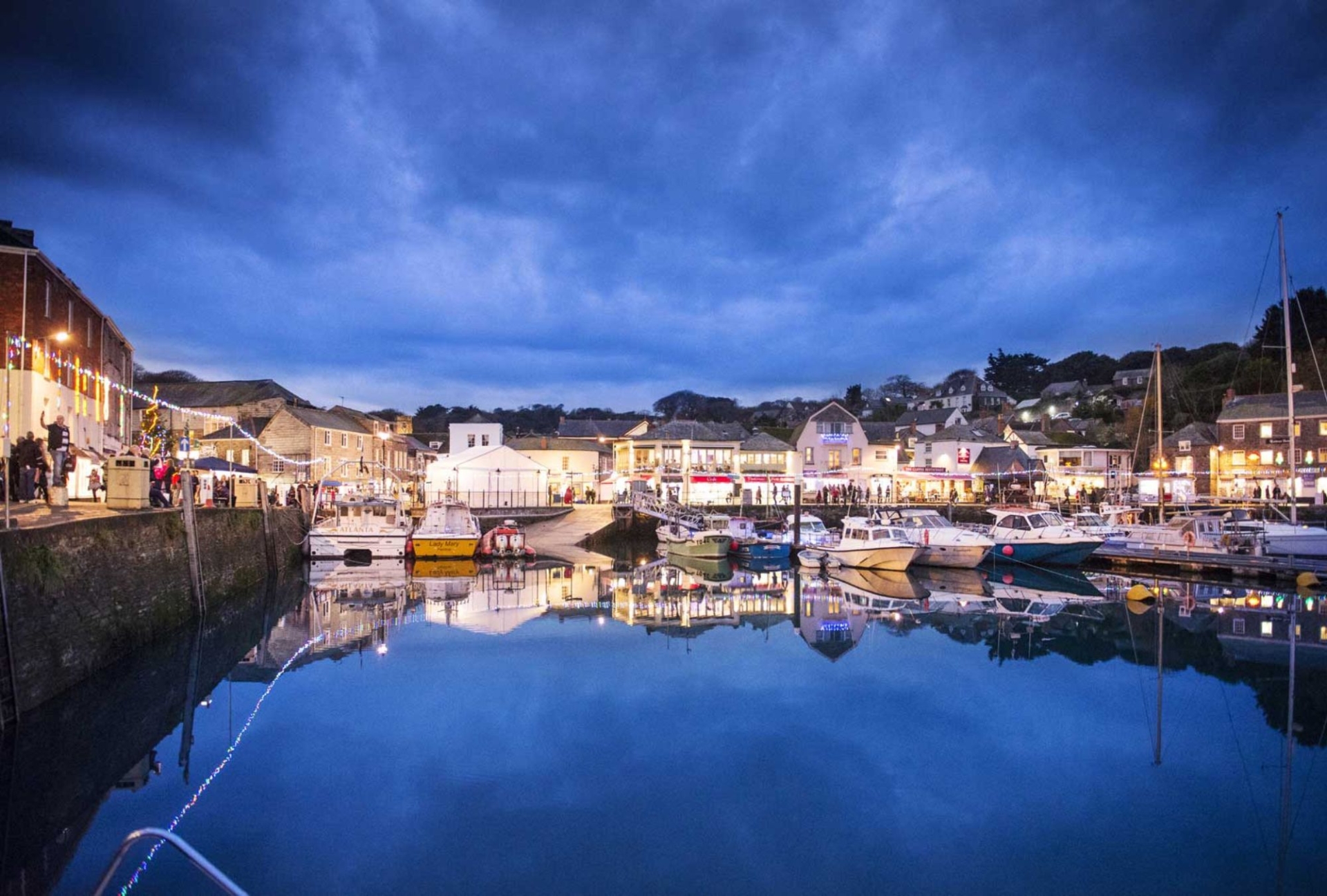 Padtstow harbour with the tide in surorunded by christmas lights